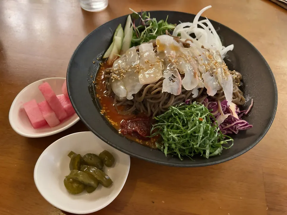A bowl of spicy buckwheat noodles topped with flounder
