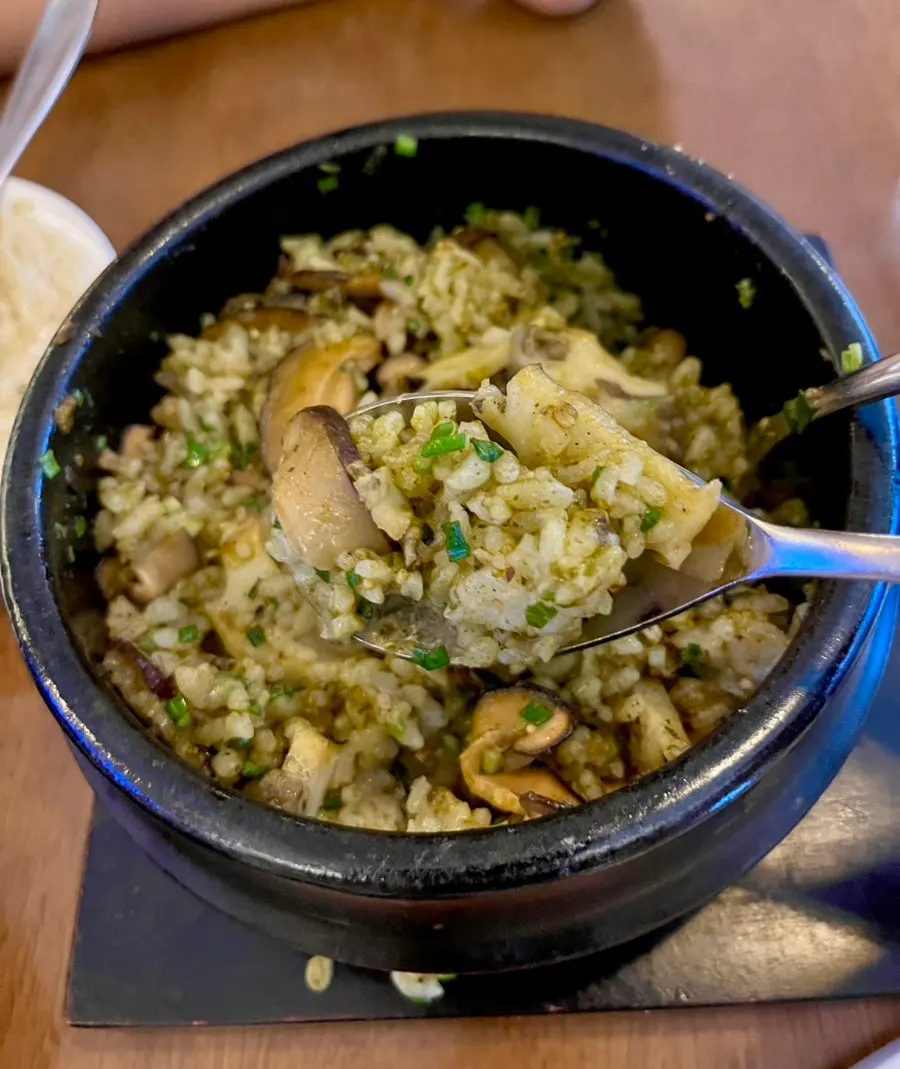 A spoonful of pot rice mixed with abalone innards sauce