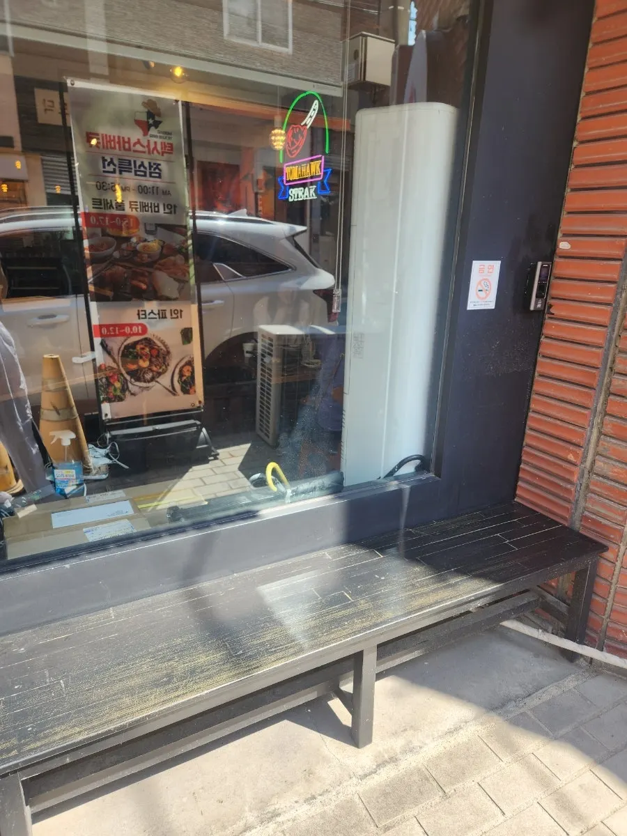 Barbecue setup and waiting chairs at the store entrance