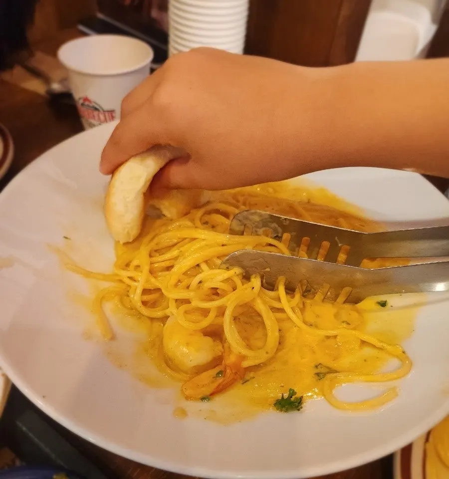 Dipping a dinner roll into the cream sauce