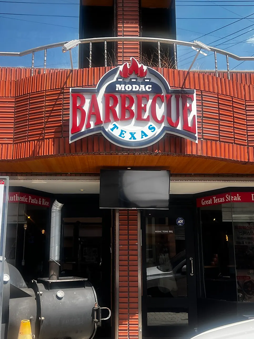 Modak Texas Barbecue sign and outdoor barbecue setup
