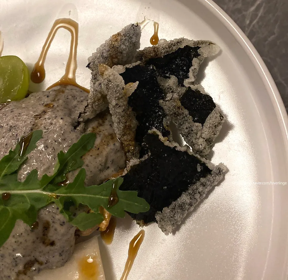 Eggplant dish plated with fried gim chips and fruit