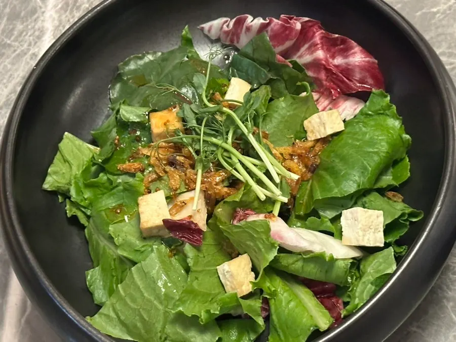 Mustard seed dressing salad topped with barley shrimp chips