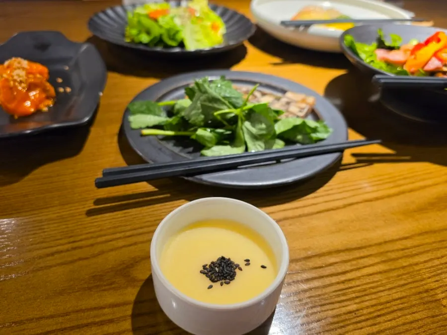 Black sesame mung bean porridge plated with appetizers
