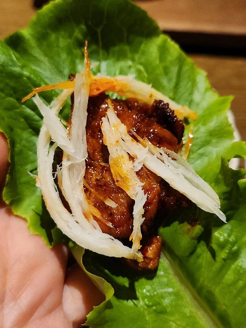 A wrap of pork topped with deodeok