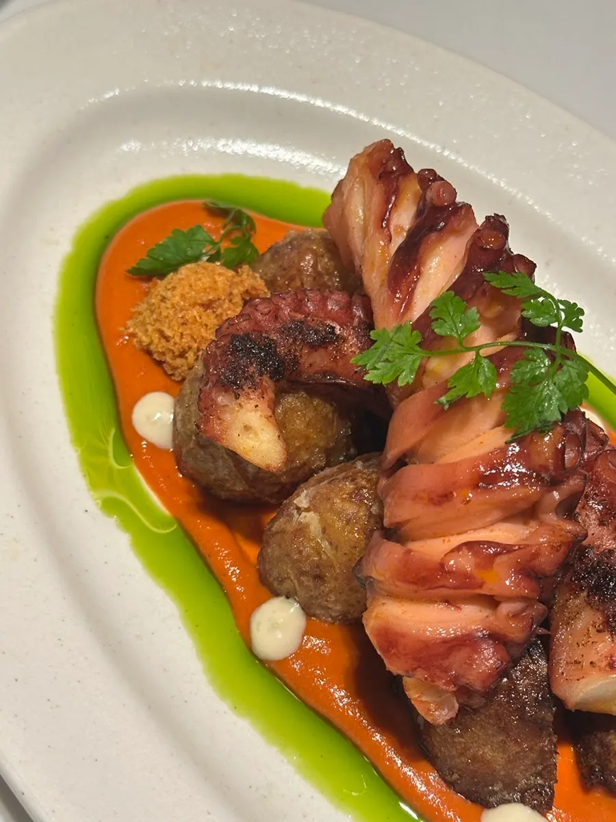 MOI's octopus steak plated over romesco sauce