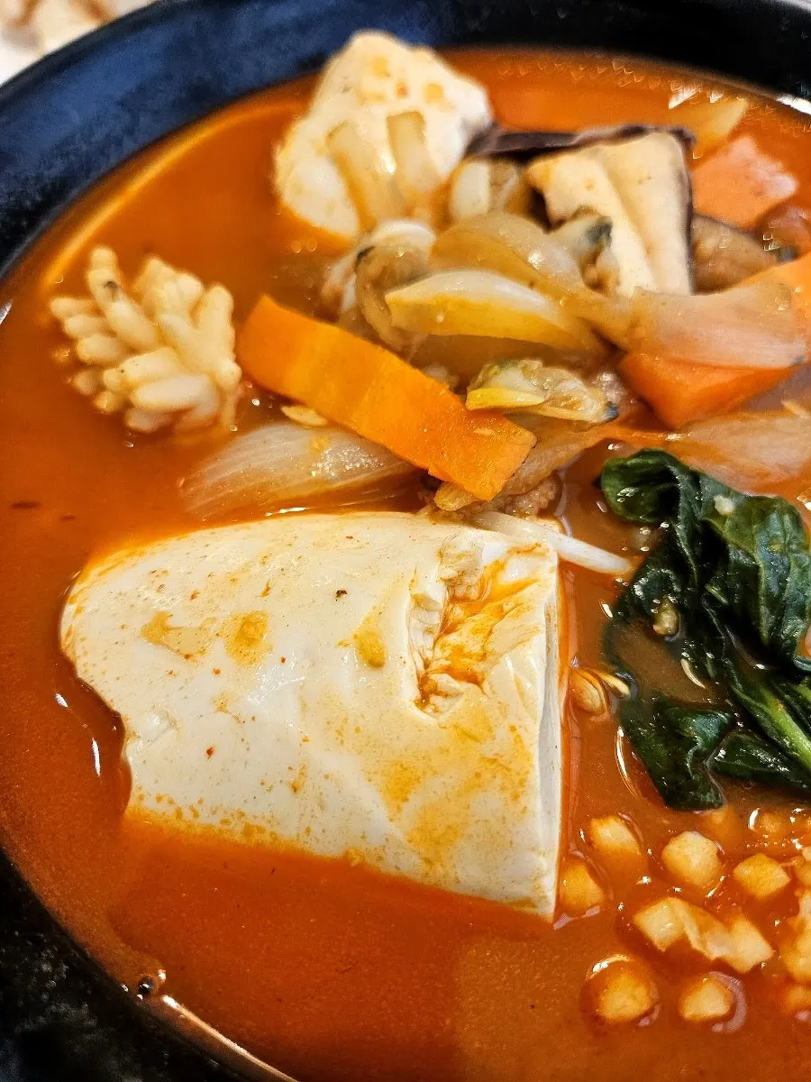 Close-up of sundubu jjampong topped with large soft tofu chunks