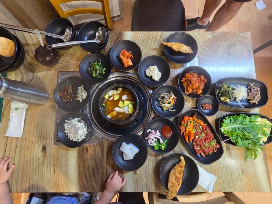 Table spread with grilled deodeok, grilled hwangtae, and wrap greens added