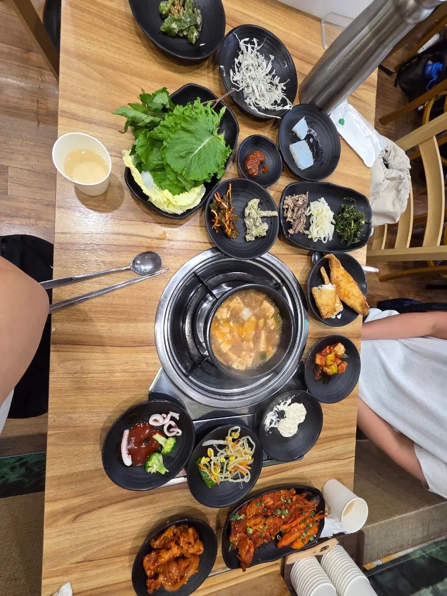 Full spread of hanjeongsik side dishes including grilled fish and namul