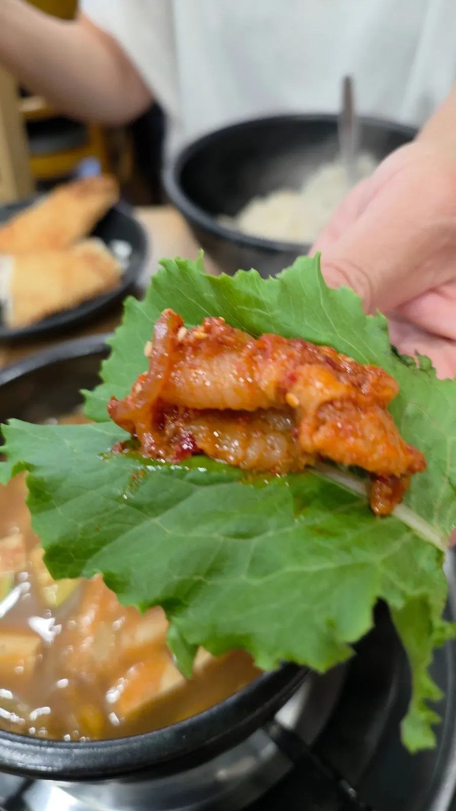 Stir-fried pork piece placed on ssam greens