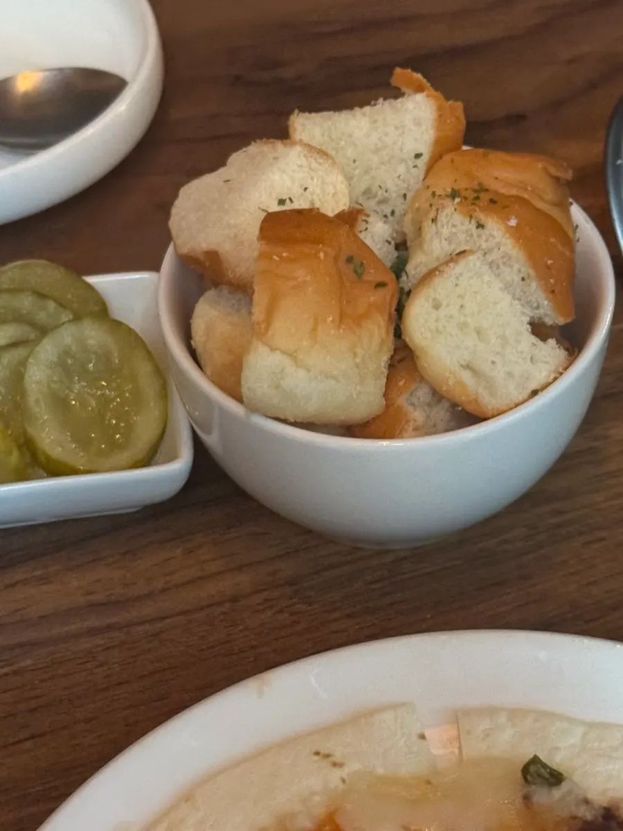 Shrimp fondue table setting with tortilla pizza and dinner rolls
