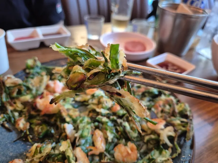 Picking up a piece of the shrimp chive pancake