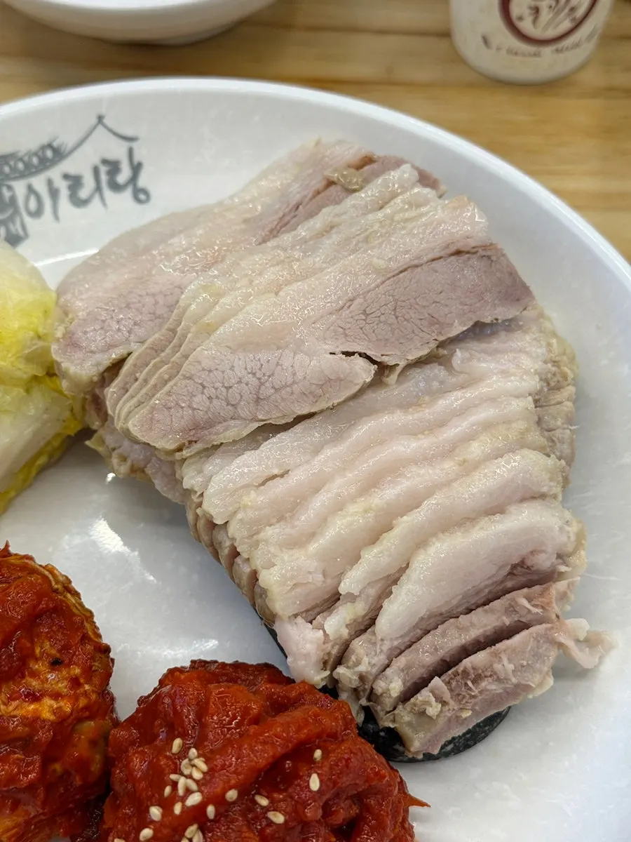 Bossam with kimchi, shredded dried radish, and cabbage