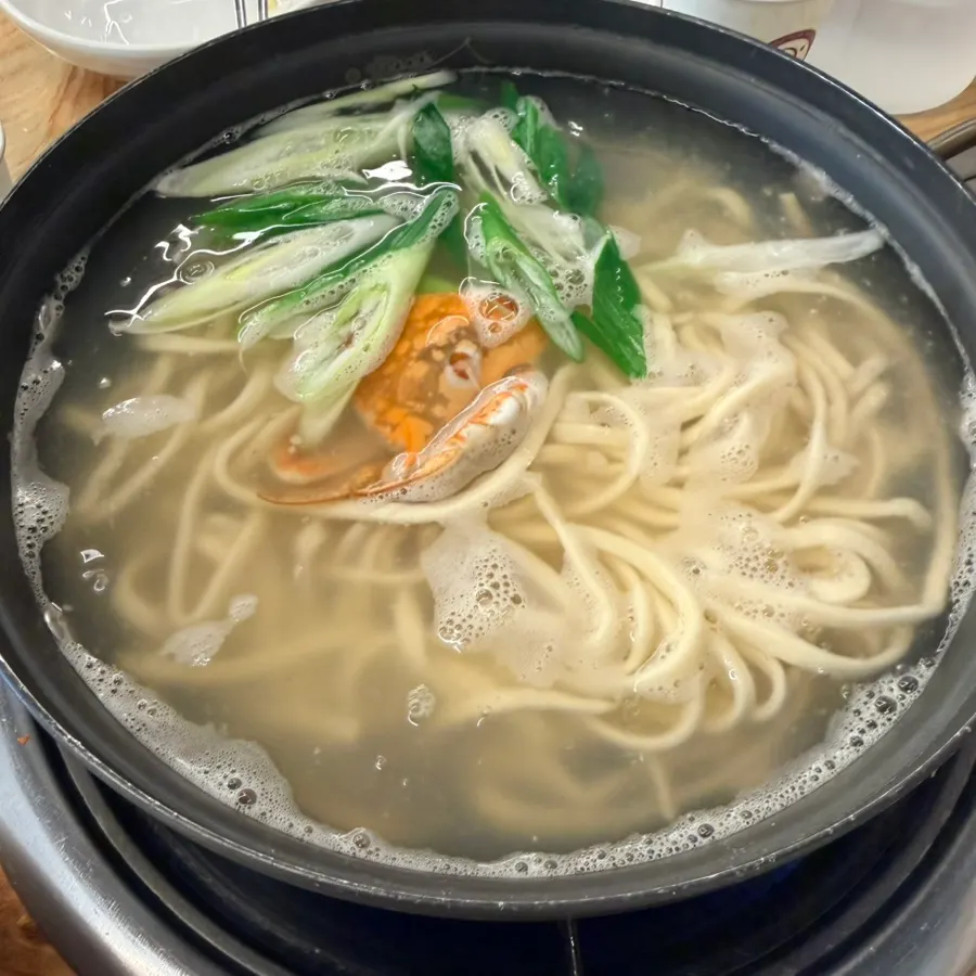 Complimentary kalguksu topped with crab and clams