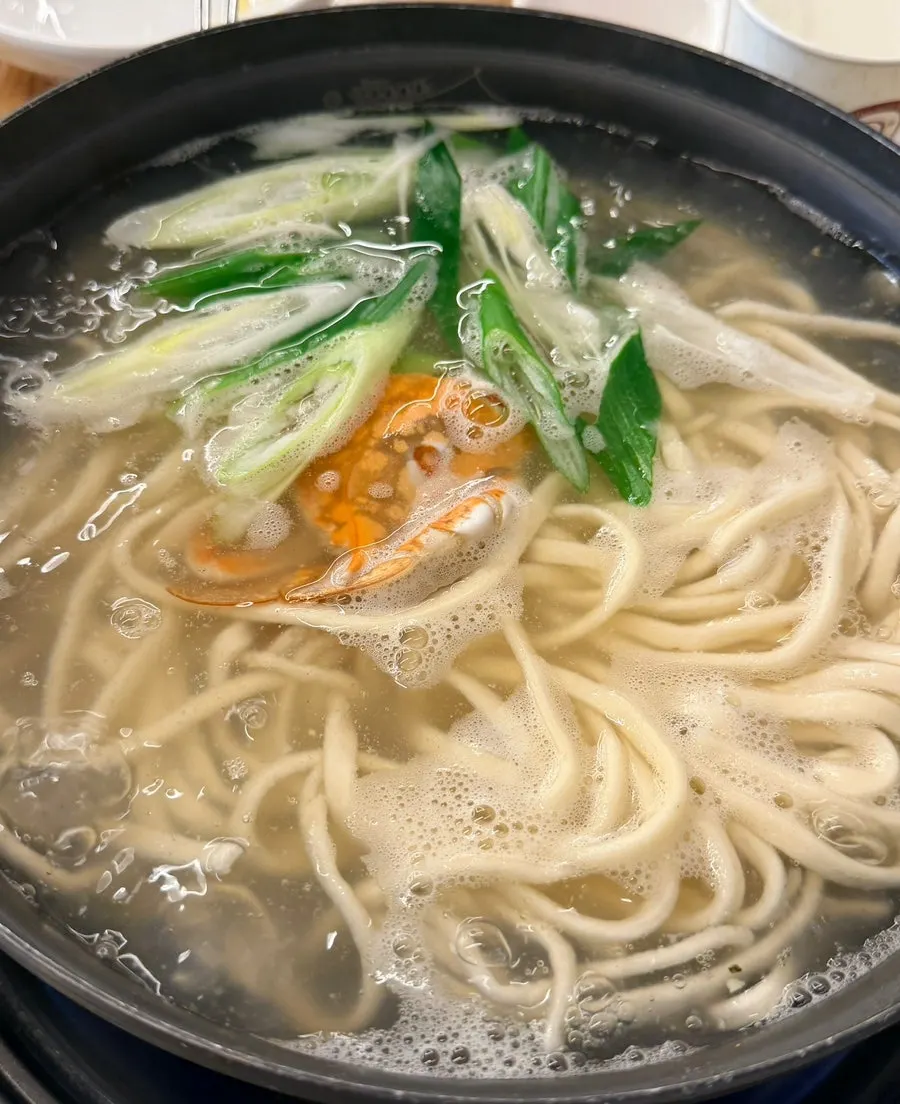 Clam kalguksu noodles being served after simmering