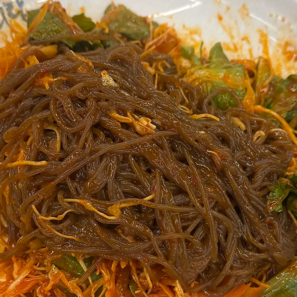 새콤한 양념 막국수를 집어 든 모습