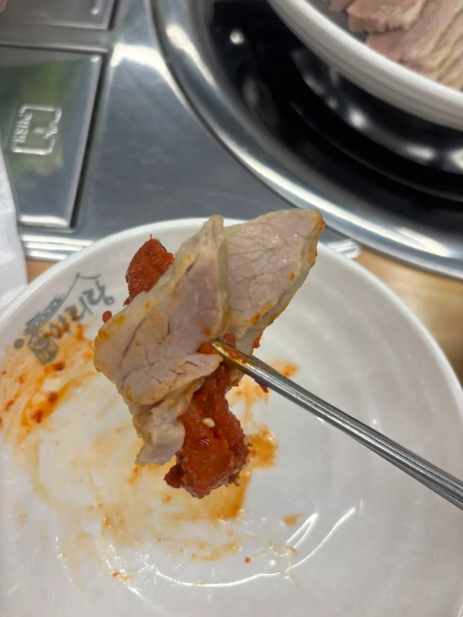 A bossam wrap topped with mumallaengi