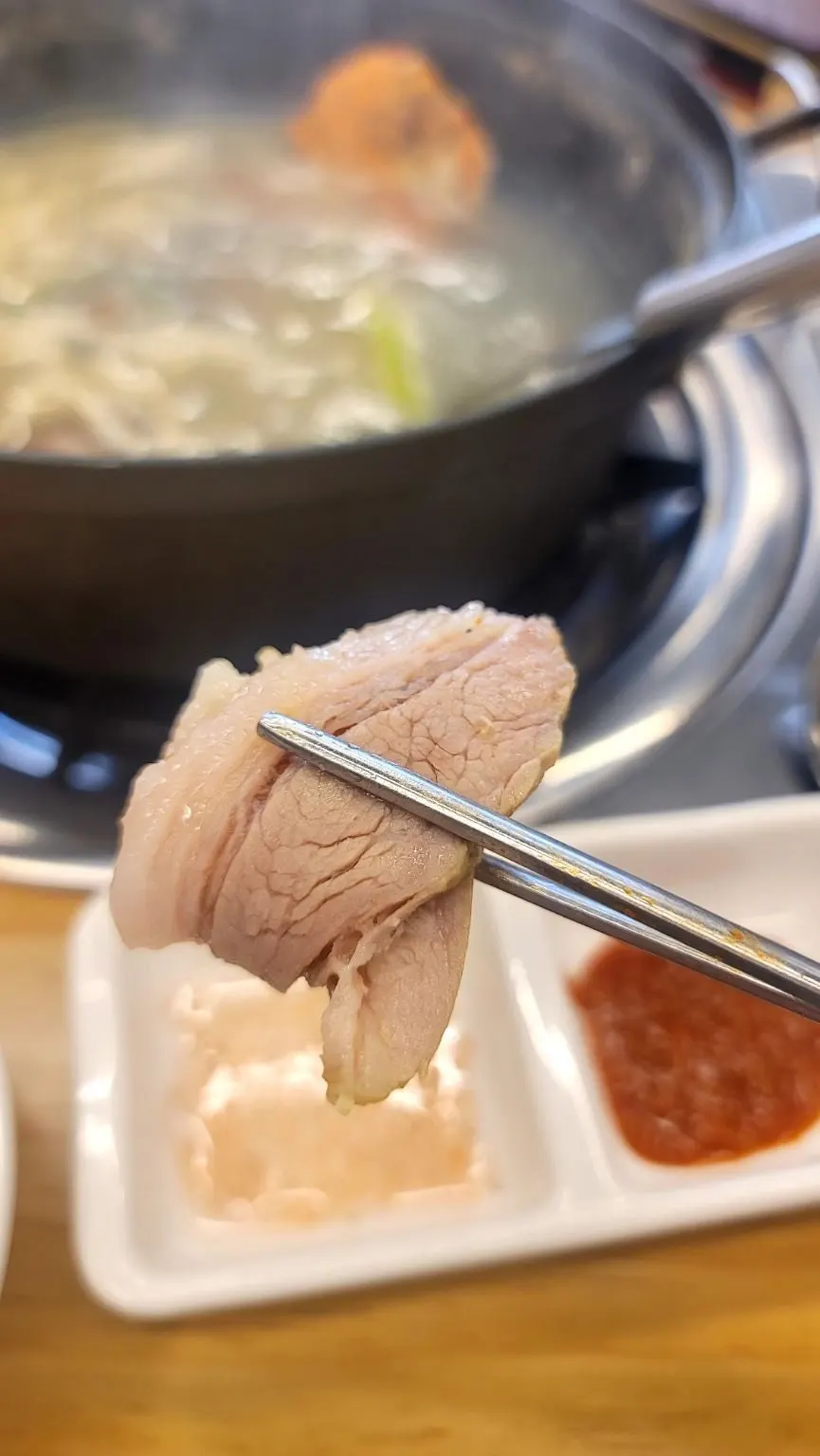 A piece of gabrisal bossam lifted with chopsticks