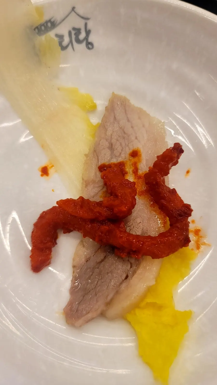 A bossam wrap with pork rolled in kimchi