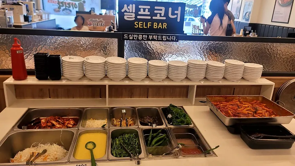 Self-serve bar with tteokbokki and side dishes
