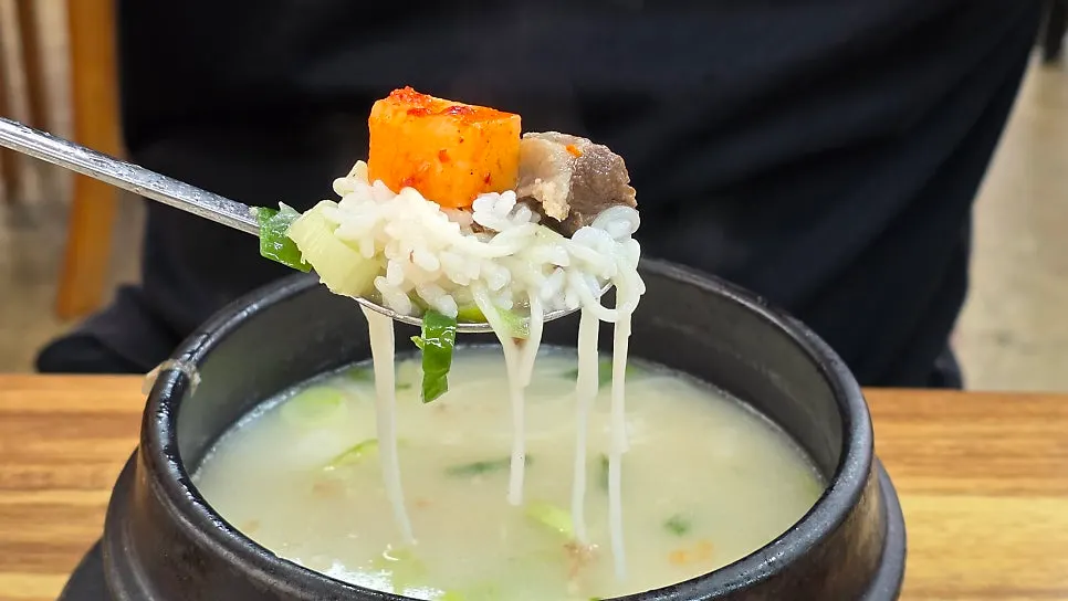 Gomtang with noodles added, alongside cubed radish kimchi