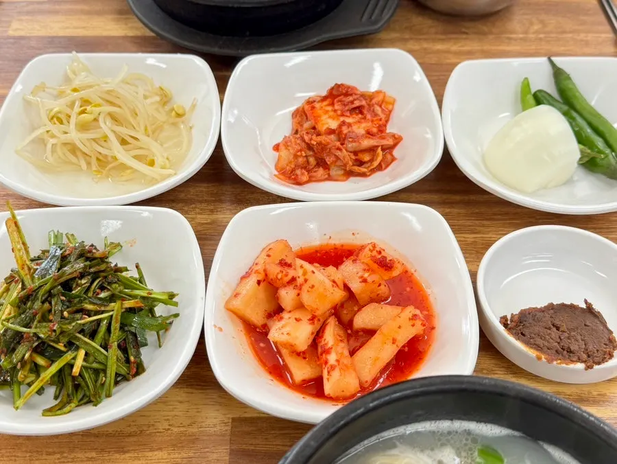 A spread of basic side dishes including bean sprouts and kimchi