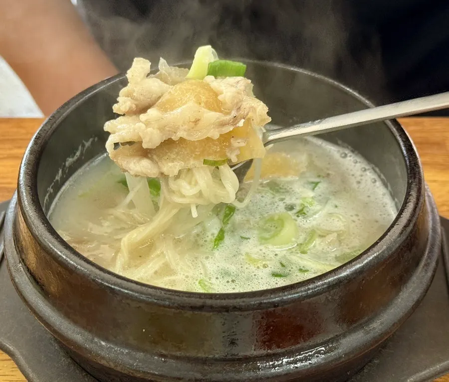 Doganitang topped with noodles, scallions, and pepper