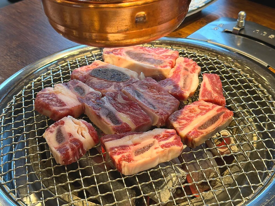 직원이 불판에 소 생갈비를 굽는 모습