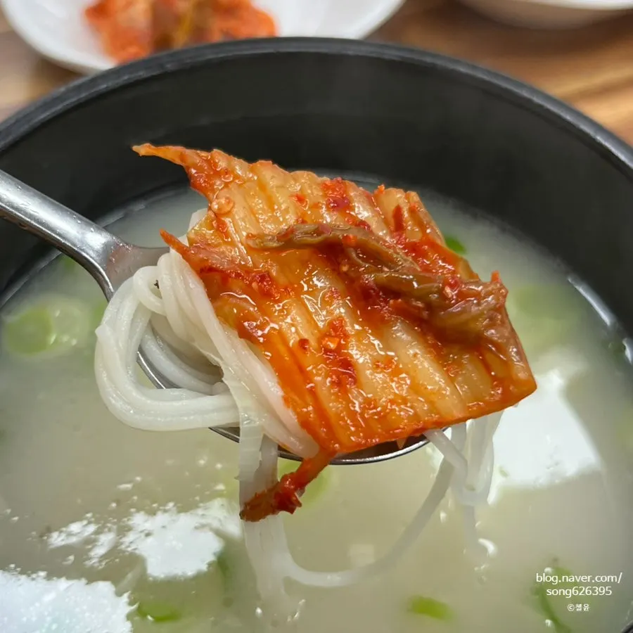 A bite of oxtail bone topped with radish kimchi