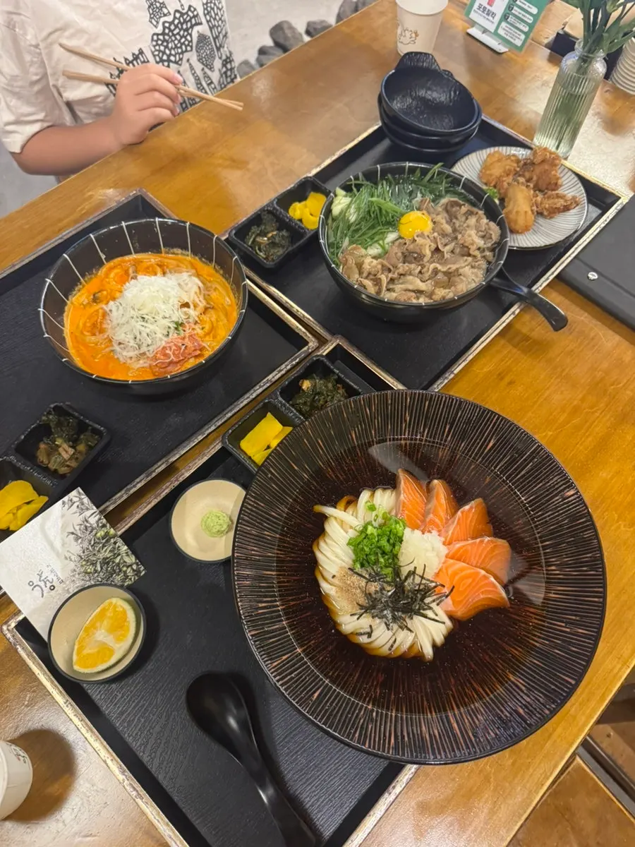 테이블에 차려진 우동 세 그릇과 가라아게