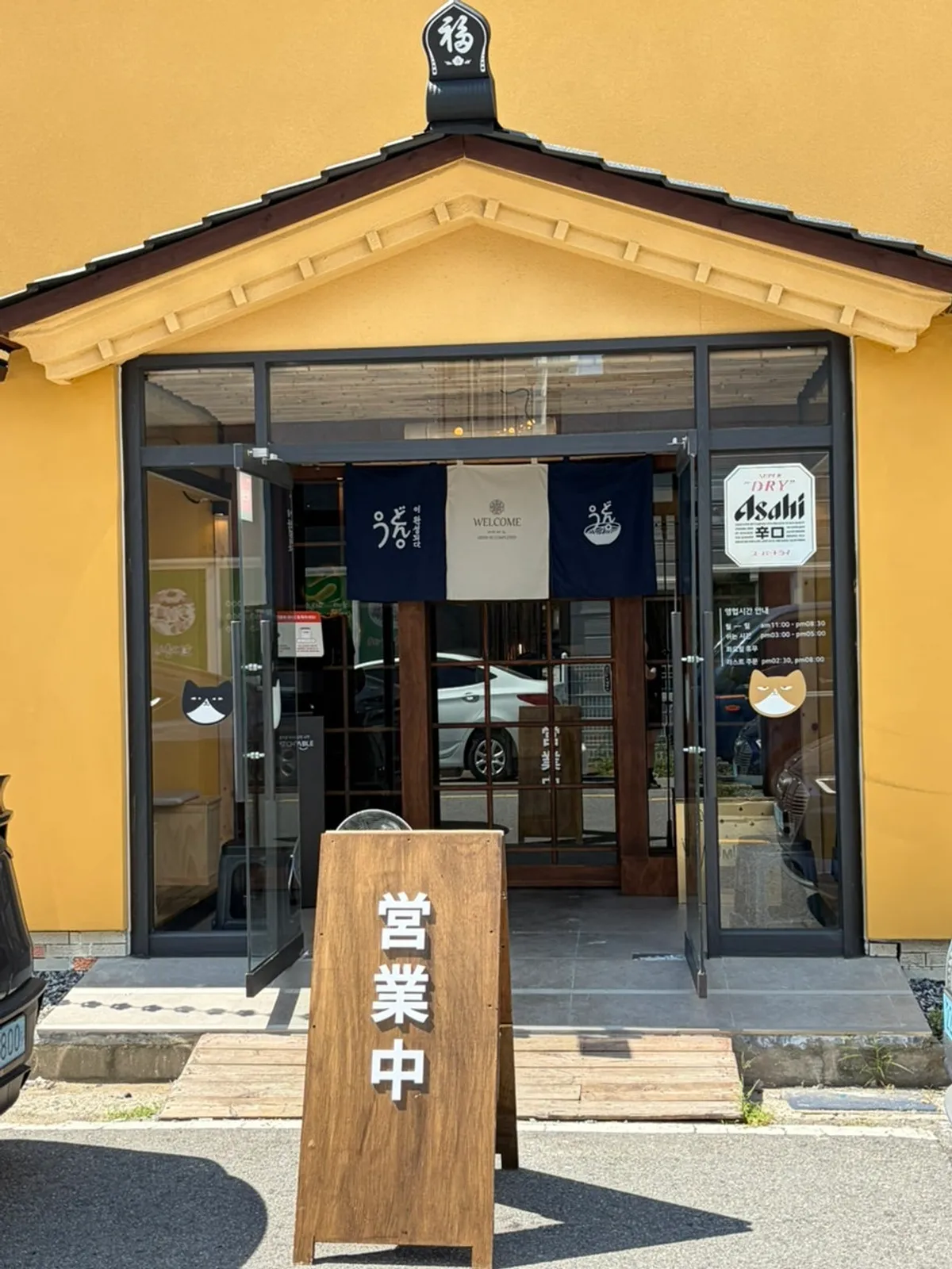 Yellow and wood-tone udon restaurant exterior
