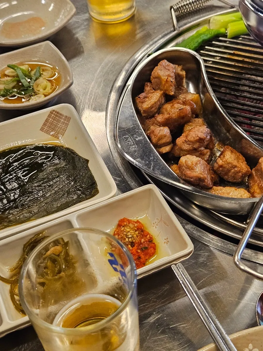 Full table spread with pork neck and side dishes