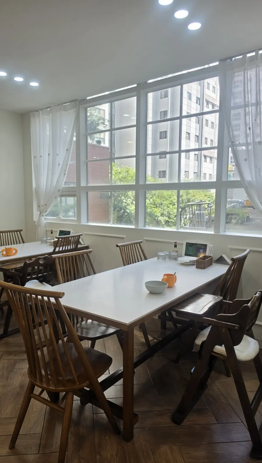 Seating by grid-patterned windows with white curtains