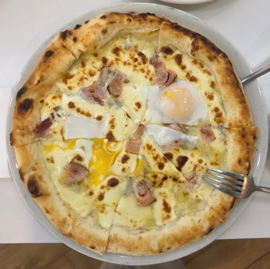 Blue Cheese Bismarck pizza topped with a soft-boiled egg