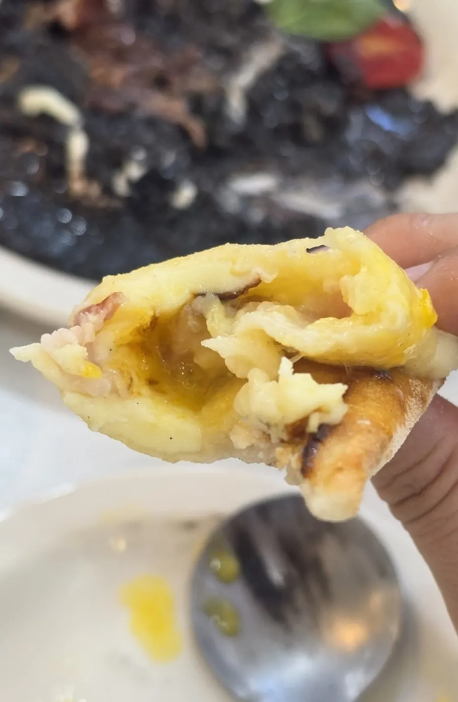 A slice of pizza with yolk spread over it