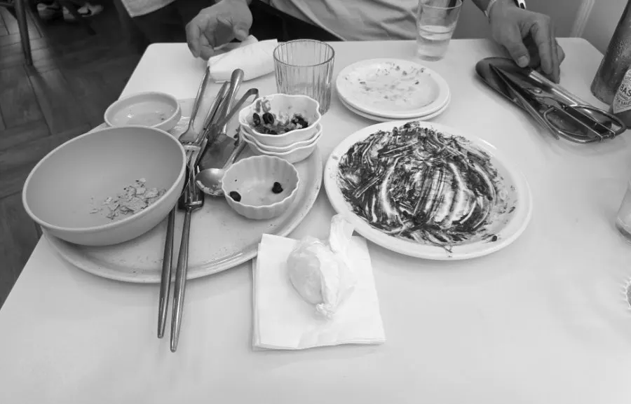 Table with pizza and squid ink risotto together