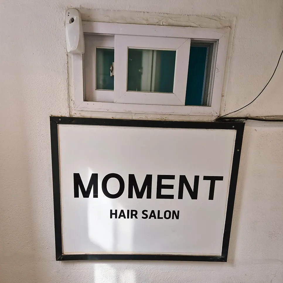 Sign for Moment Hair Suraksan Station Branch on the 2nd floor of a building on Dongil-ro