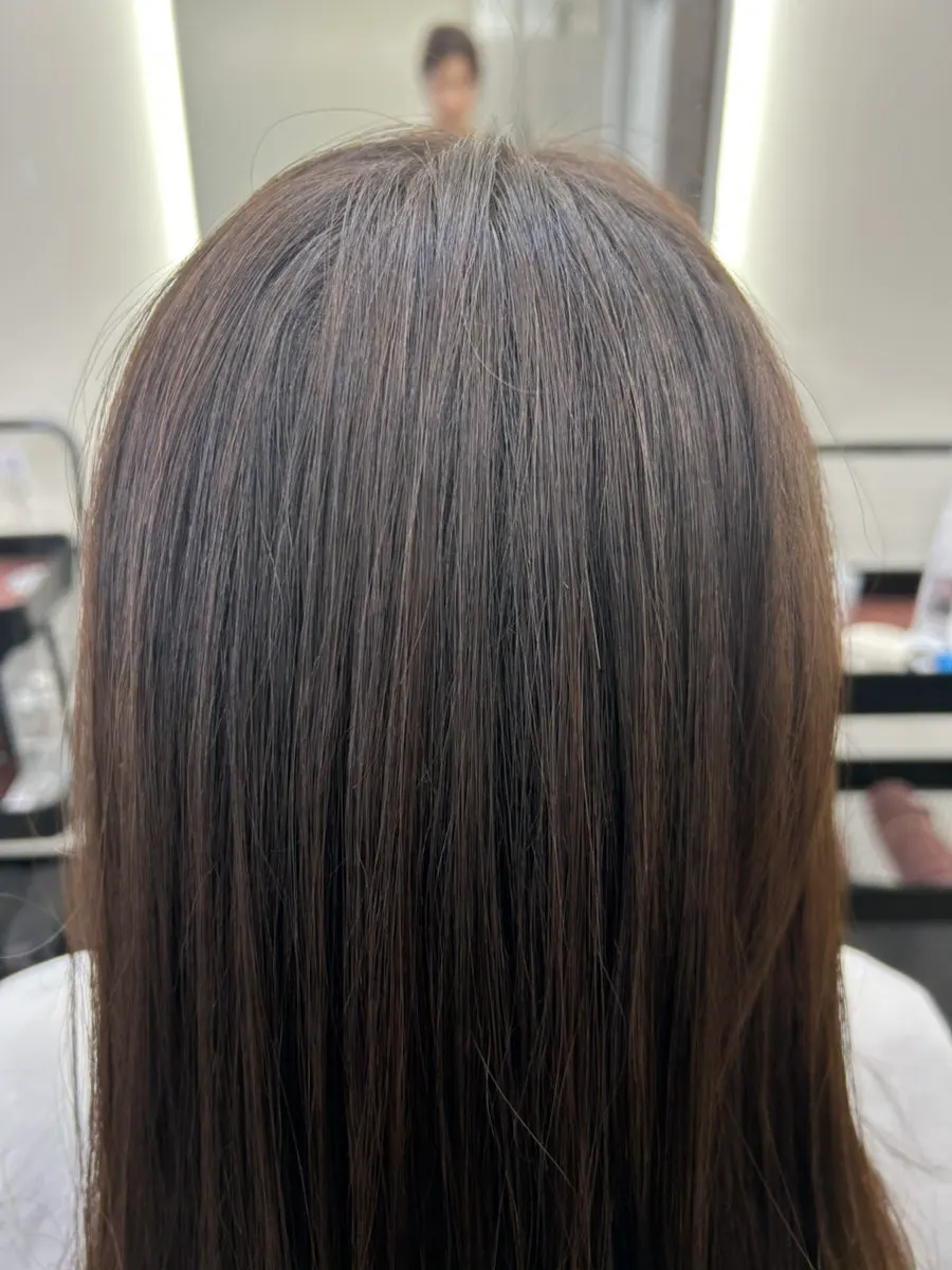 Back view of hair, curl-free and neatly styled after treatment