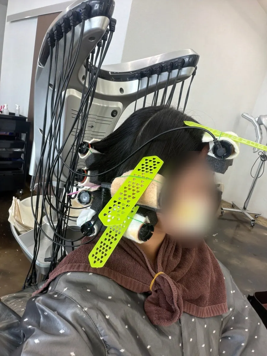 Hair rolled onto rods with heat applied during the perm process