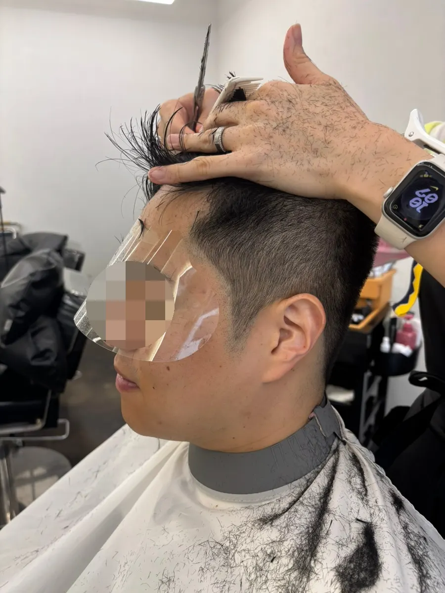A cover shielding the eyes during a bangs trim
