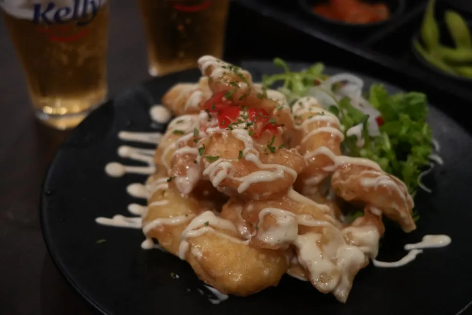 Fried shrimp being dipped into mayo sauce