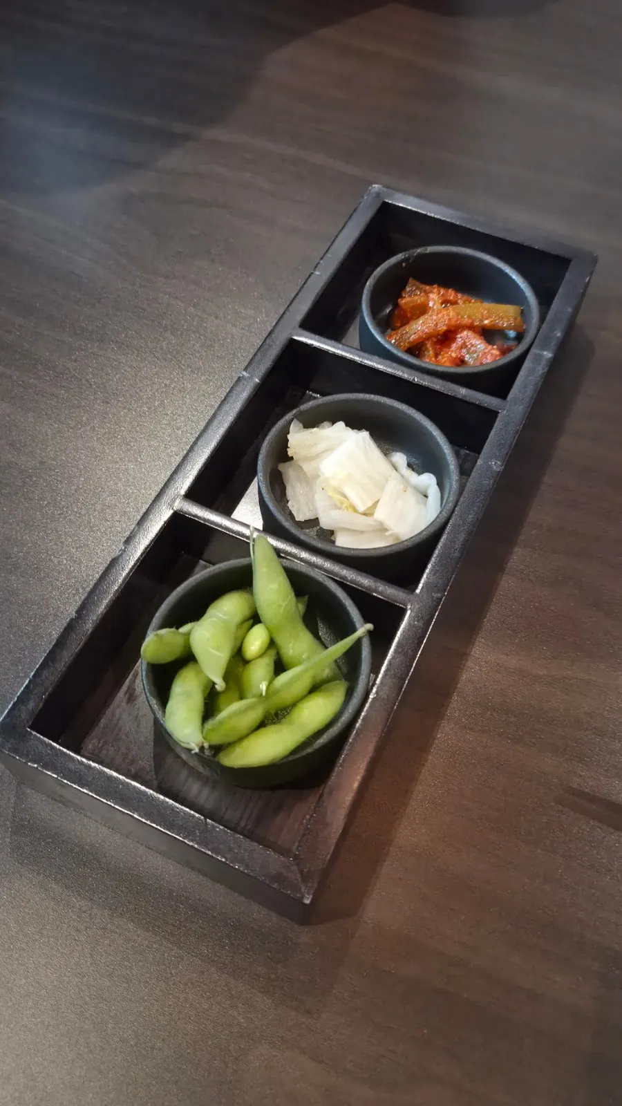 Tray of the three basic side dishes: edamame, white kimchi, and gungchae jangajji