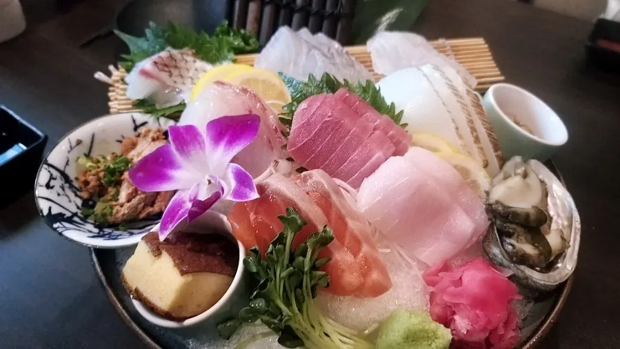 Seasonal mixed sashimi (small) presented with dry ice and fresh flowers