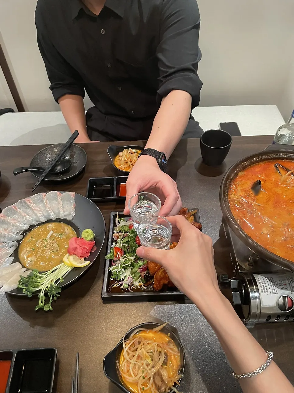 A full spread of sashimi, nabe, and karaage on the table