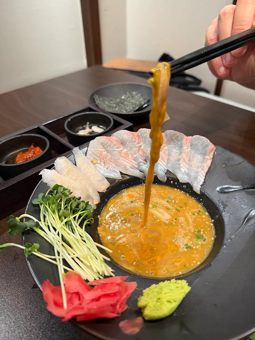 Thinly sliced whitefish sashimi with sea cucumber innards sauce