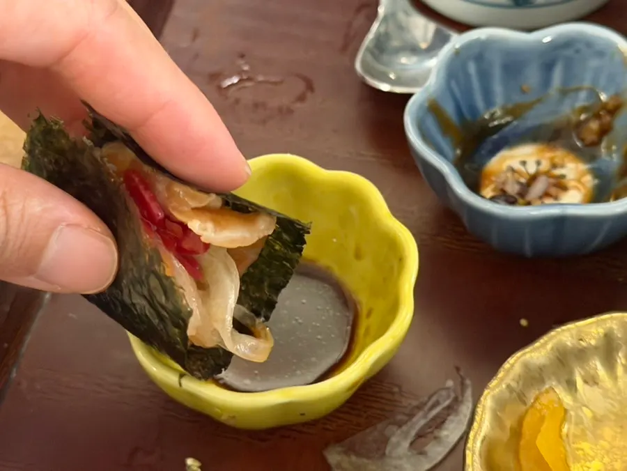A piece of salmon dipped in soy sauce