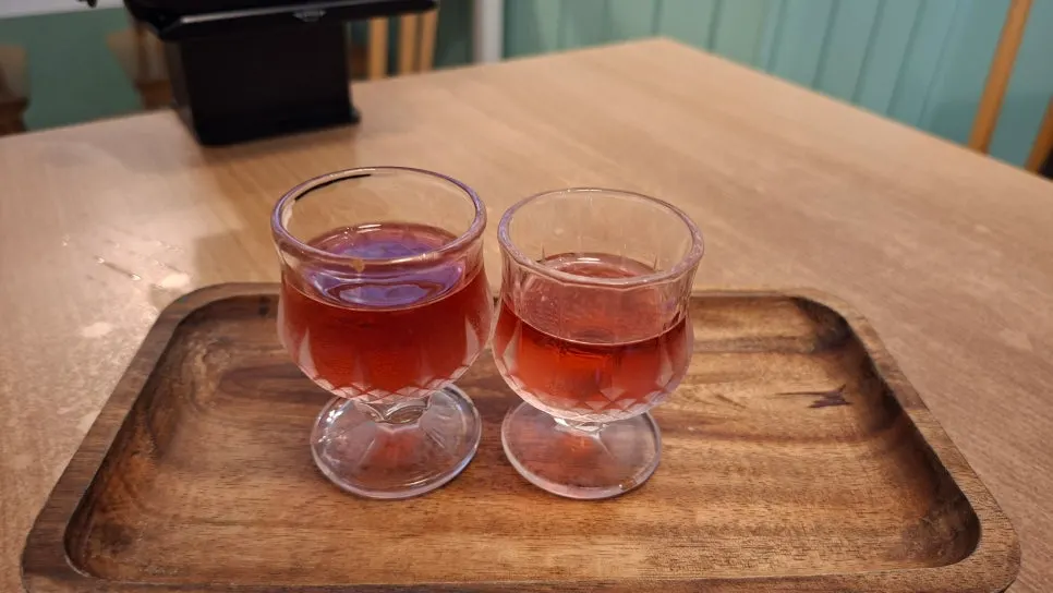 A glass of omija tea served as a pre-meal drink at Momo Lab