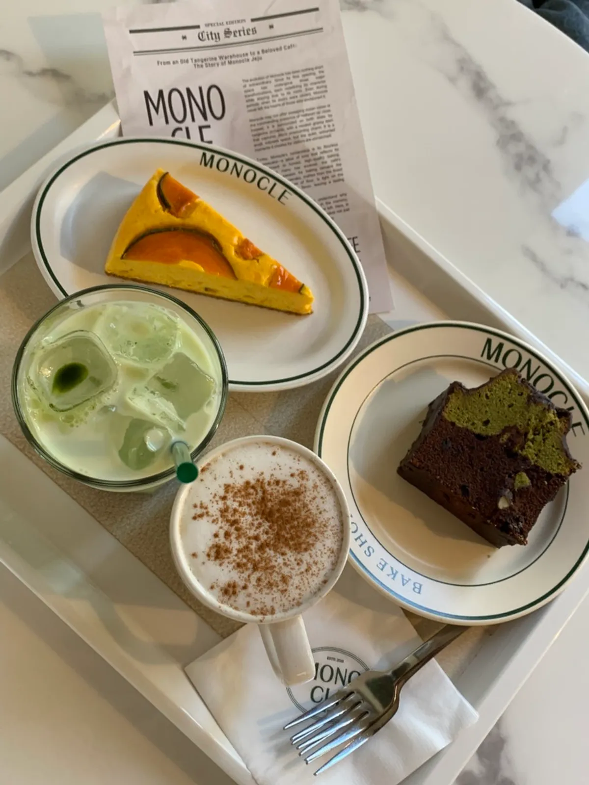 Table setting with sweet pumpkin cheesecake, matcha pound cake, and two lattes