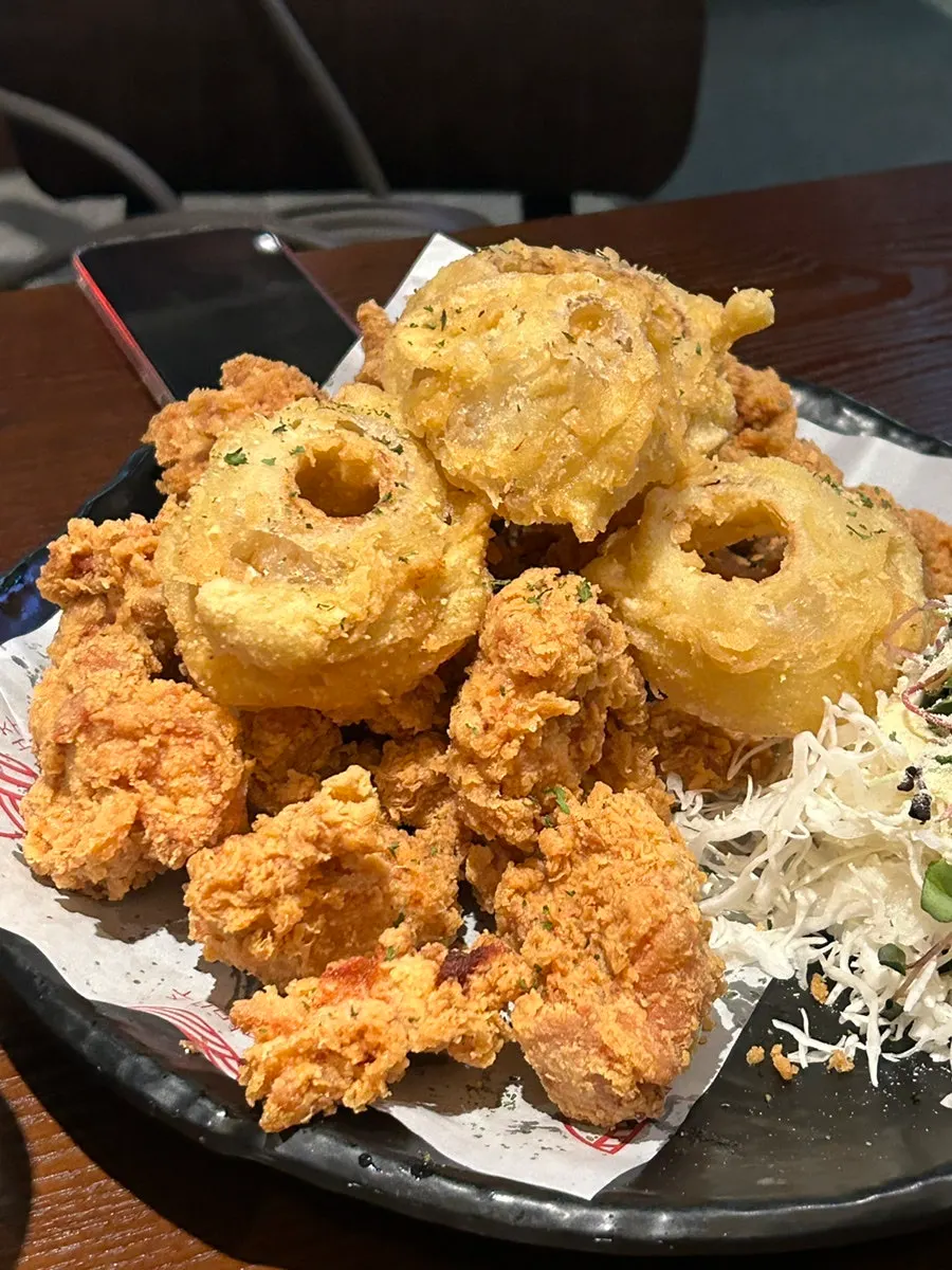 Plate of crispy fried chicken with onion rings