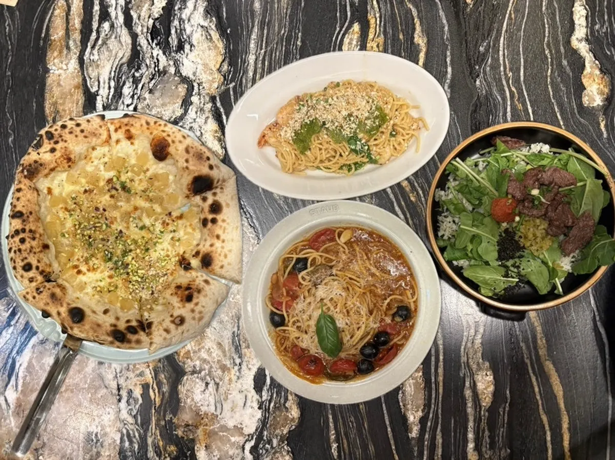 Full spread of pasta, pizza and bibimbap on the table